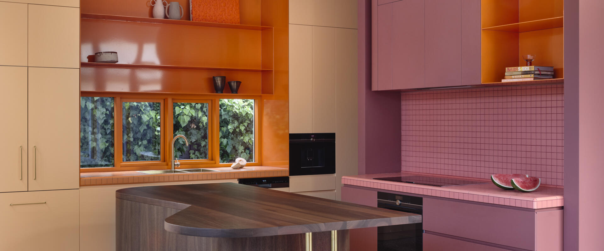 Vibrant pink and orange kitchen featuring timber windows by Pickering Joinery