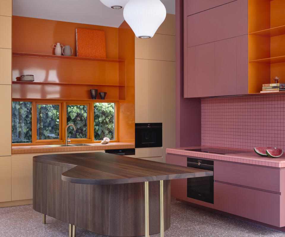 Vibrant pink and orange kitchen featuring timber windows by Pickering Joinery