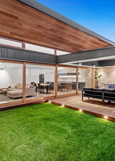 Outdoor entertainment area featuring a wall of glass timber windows and doors by Pickering Joinery