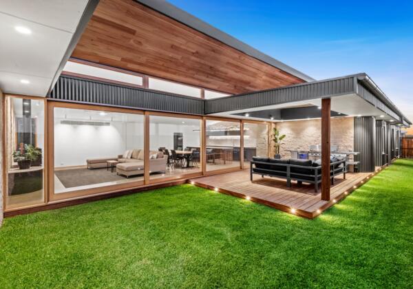 Outdoor entertainment area featuring a wall of glass timber windows and doors by Pickering Joinery