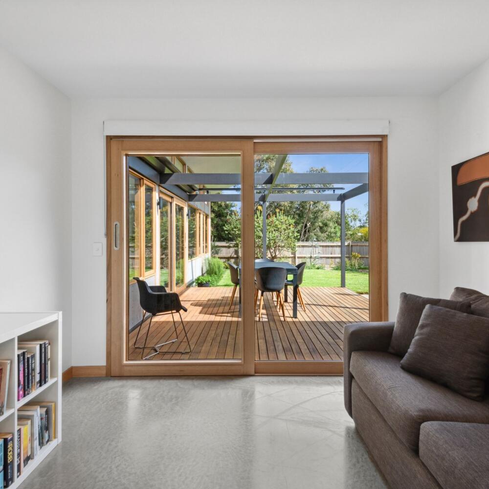 A small lounge space with a large timber glazed sliding door to the garden