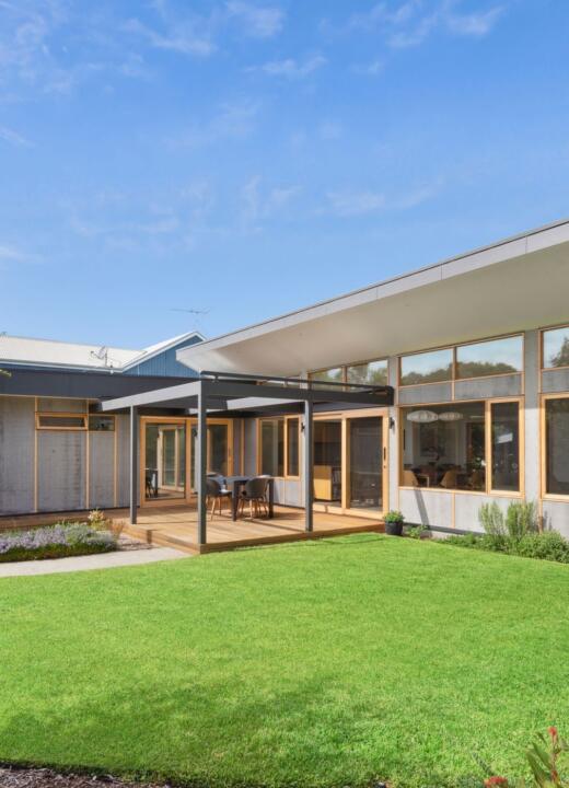 View of beautiful home and timber windows and doors from native backyard